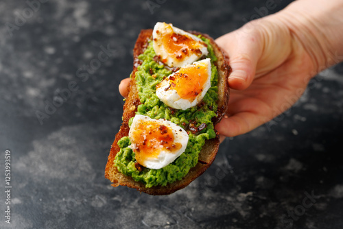 Smashed peas and egg sourdough toast with whole grain mustard sauce. Protein packed vegetarian food concept photo