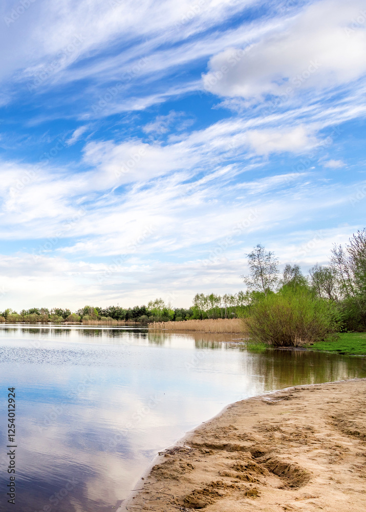 Obraz premium Beautiful lake with a cloudy sky in the background