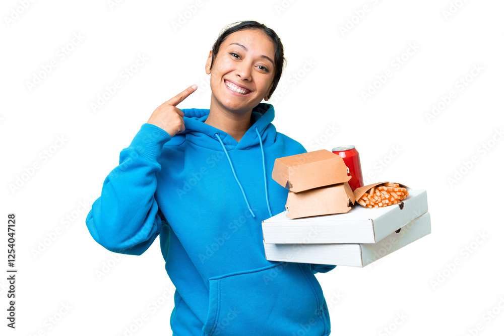 Young Uruguayan woman holding pizzas and burgers over isolated chroma key background giving a thumbs up gesture Young Uruguayan woman holding pizzas and burgers over isolated chroma key background giving a thumbs up gesture