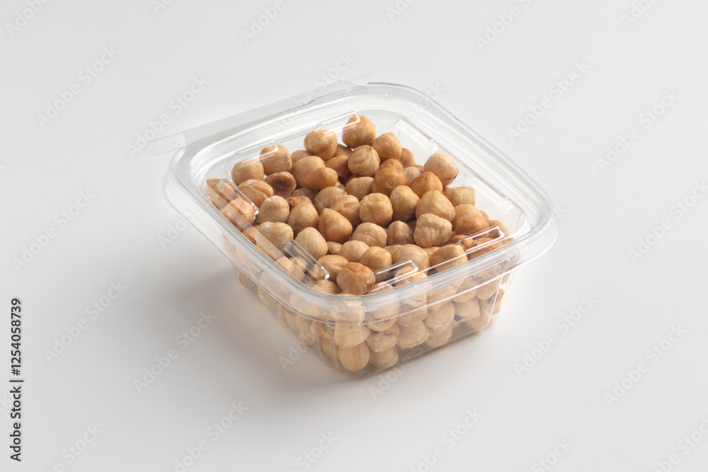 Nuts in a transparent plastic box isolated on white background, close up, food photography, mock up. Pile of shelled hazelnuts in plastic packaging.
Nuts in a transparent plastic box isolated on white background, close up, food photography, mock up. Pile of shelled hazelnuts in plastic packaging.