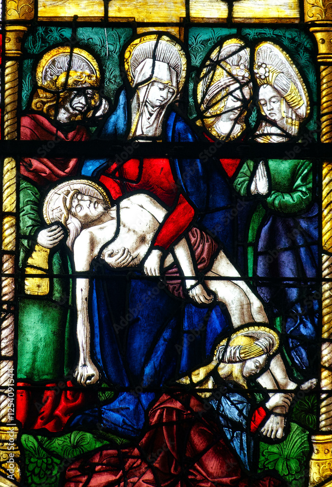 Fototapeta premium Stained glass (19th century) of The Pietà. Blessed Virgin Mary holding Jesus Christ body after his Deposition from the Cross..