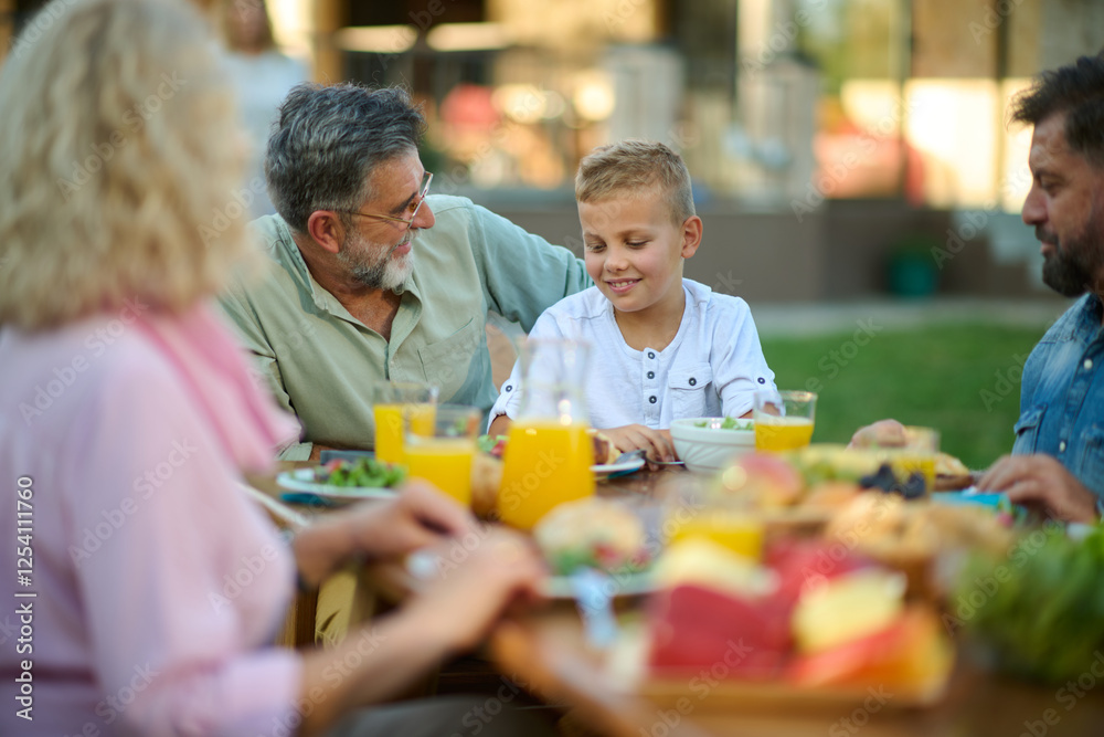 Happy family having lunch in the backyard on a sunny day Happy family having lunch in the backyard on a sunny day