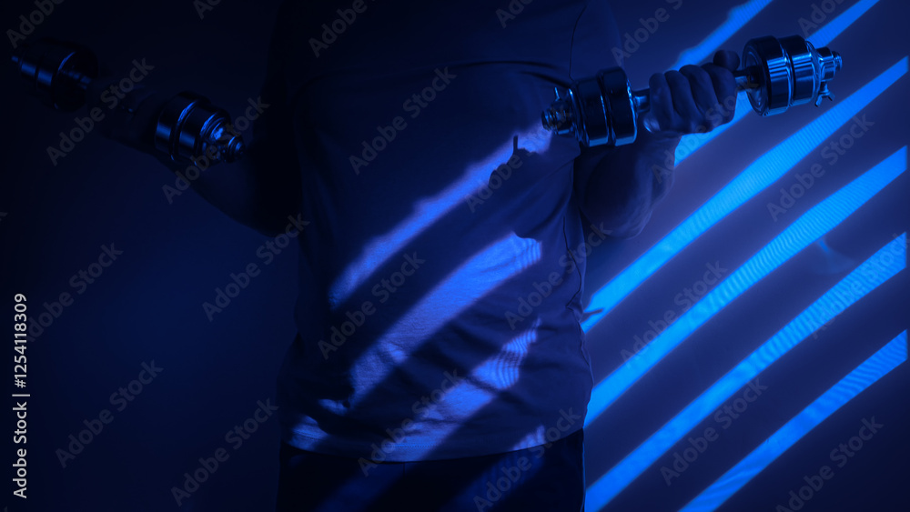 Athlete lifting dumbbells in dramatic blue lighting with shadows