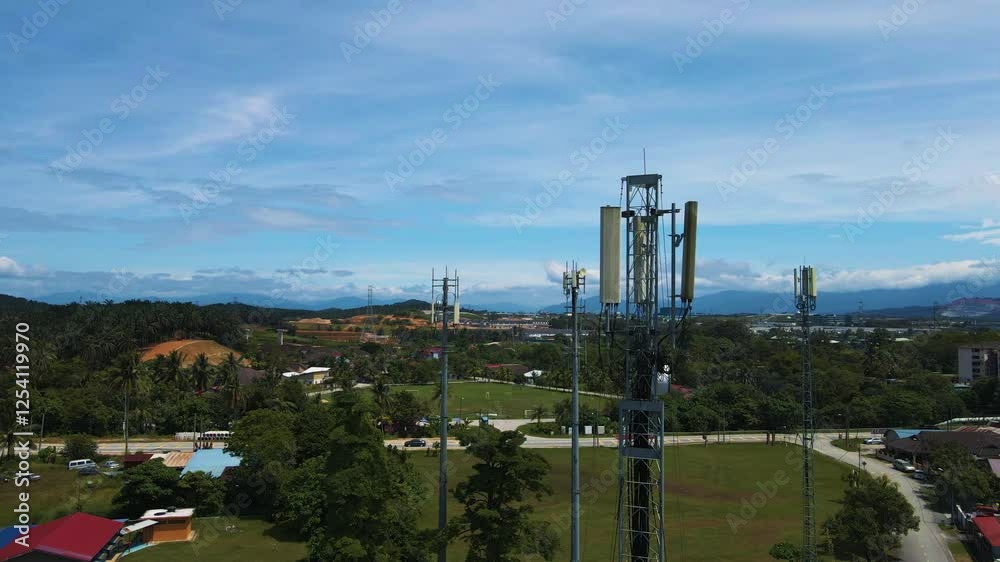 Aerial 4K view of 5G antennas towering above a suburban area, surrounded by greenery and distant mountains. Ideal for telecommunications and technology projects. Aerial 4K view of 5G antennas towering above a suburban area, surrounded by greenery and distant mountains. Ideal for telecommunications and technology projects.
