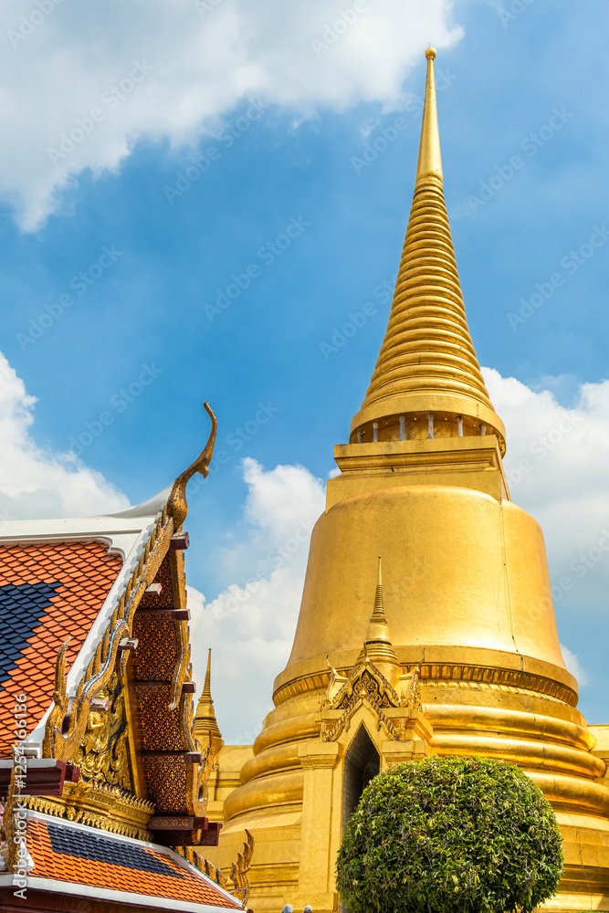 Naklejka premium Golden stupa located within Wat Phra Kaew, Temple of the Emerald Buddha, the most sacred Buddhist temple, Bangkok, Thailand. Vertical orientation. Traditional Buddhist architecture