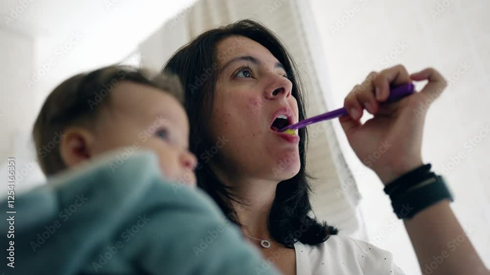 Mother brushing teeth with baby in arms, baby observing surroundings in bathroom, morning bonding, family care, daily routine, nurturing relationship, parent-child moment