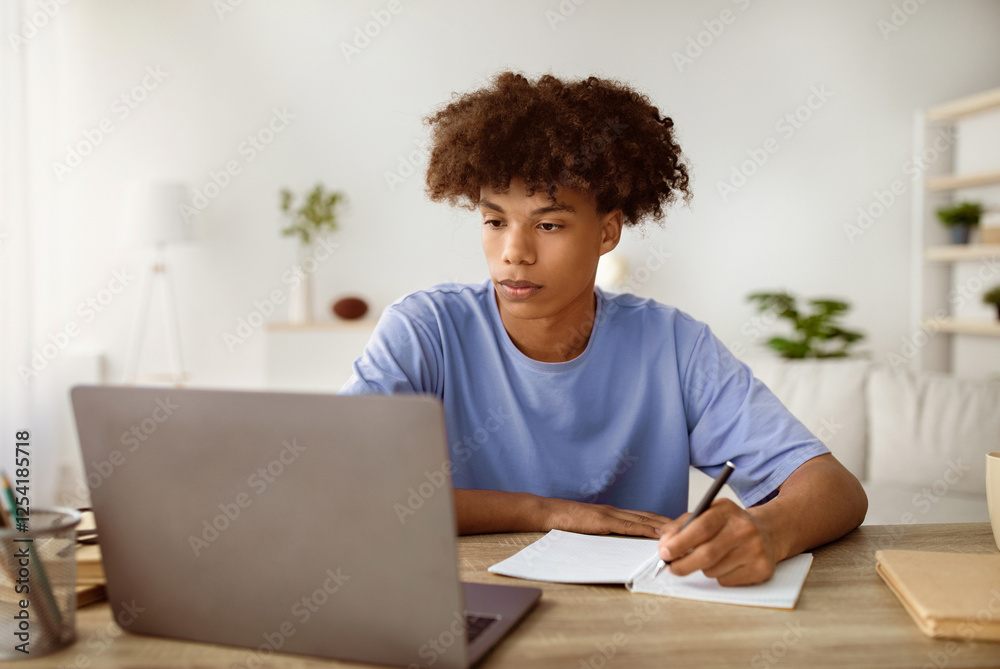 Studying from home concept. Serious black teen guy taking notes while participating in online lesson on laptop. Cool African American youth making homework, speaking to his tutor on web Studying from home concept. Serious black teen guy taking notes while participating in online lesson on laptop. Cool African American youth making homework, speaking to his tutor on web