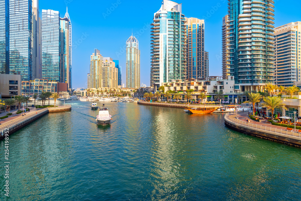 Obraz premium The Dubai Marina, a waterfront promenade of shops, boat marinas and skyscrapers, along the coast of Dubai, United Arab Emirates along the Persian Gulf.