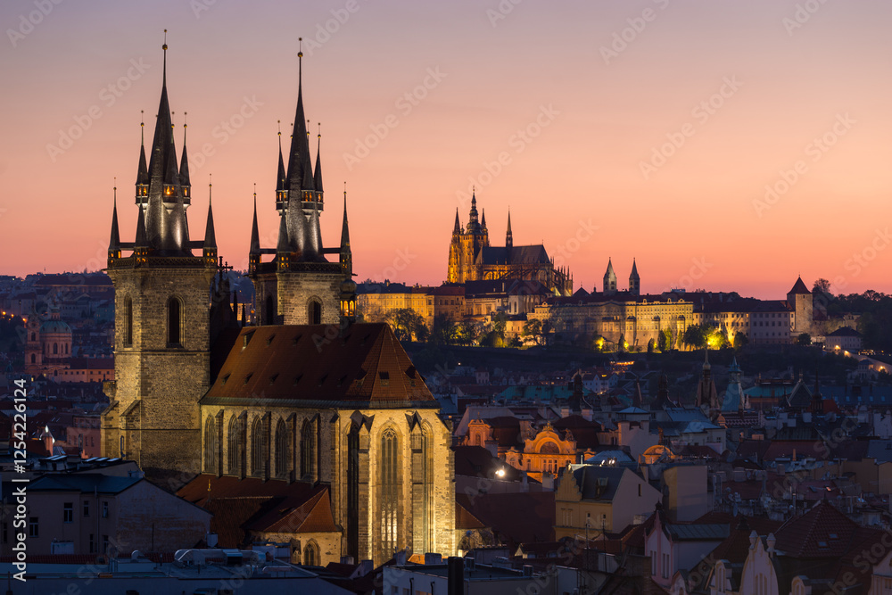 Naklejka premium Sunset view of historic Prague with St. Vitus Cathedral and gothic towers illuminated