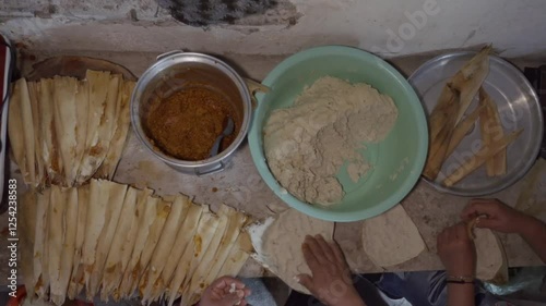 Crafting traditional Mexican tamales with green salsa and cheese filling