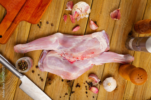 Raw goatling shoulder with rosemary and garlic. Fresh and raw meat photo
