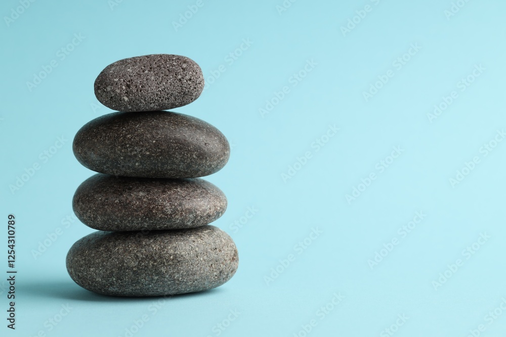 Stack of rocks on light blue background, space for text. Harmony and life balance Stack of rocks on light blue background, space for text. Harmony and life balance