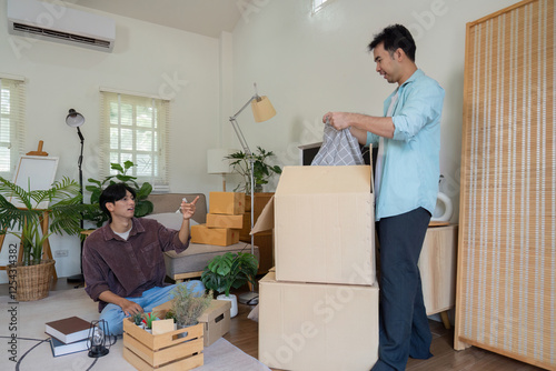 Gay couple organizing their new home, unpacking boxes and discussing decor. photo