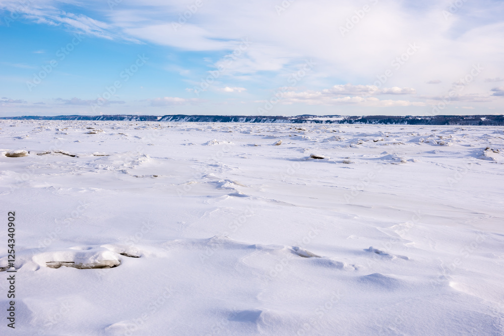 Obraz premium Winter landscape of the iced st Lawrence river in front of Neuville (Neuville, Québec, Canada)