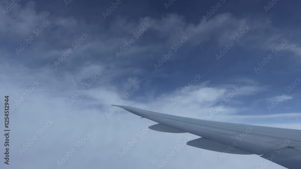 an airplane window to see the wing extending into a vast, cloud-filled sky, evoking feelings of height and tranquility. an airplane window to see the wing extending into a vast, cloud-filled sky, evoking feelings of height and tranquility.