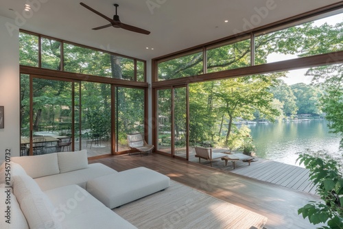 Stylish lakefront living space with large windows and serene views of nature during daylight hours