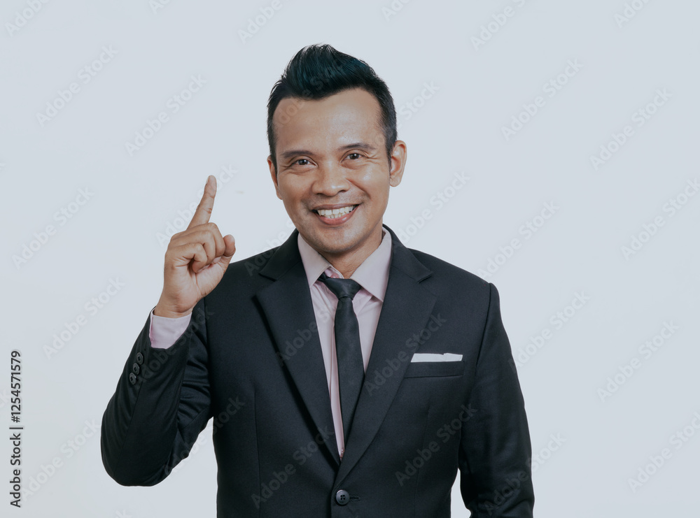 Asian boss manager businessman smiling at the camera with one hand pointing up, isolated over white background. Asian boss manager businessman smiling at the camera with one hand pointing up, isolated over white background.