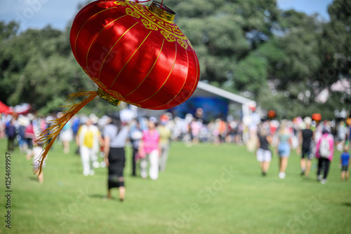 Obraz na płótnie Red lanterns hanging under the Pohutukawa trees. Unrecognizable crowd of people celebrating Chinese New Year. Auckland. w salonie