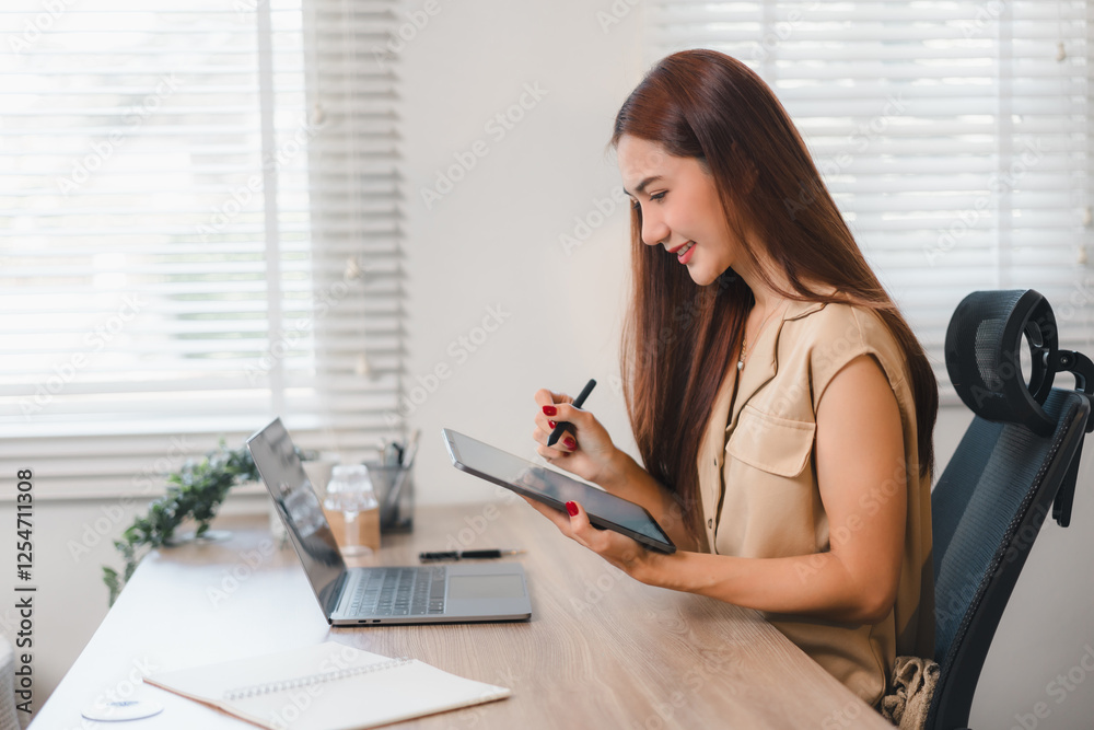 Woman working at desk with tablet and laptop, smiling in bright office environment. Woman working at desk with tablet and laptop, smiling in bright office environment.