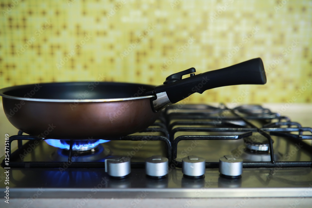 Frying Pan on Gas Stove with Blue Flame in Modern Kitchen Frying Pan on Gas Stove with Blue Flame in Modern Kitchen