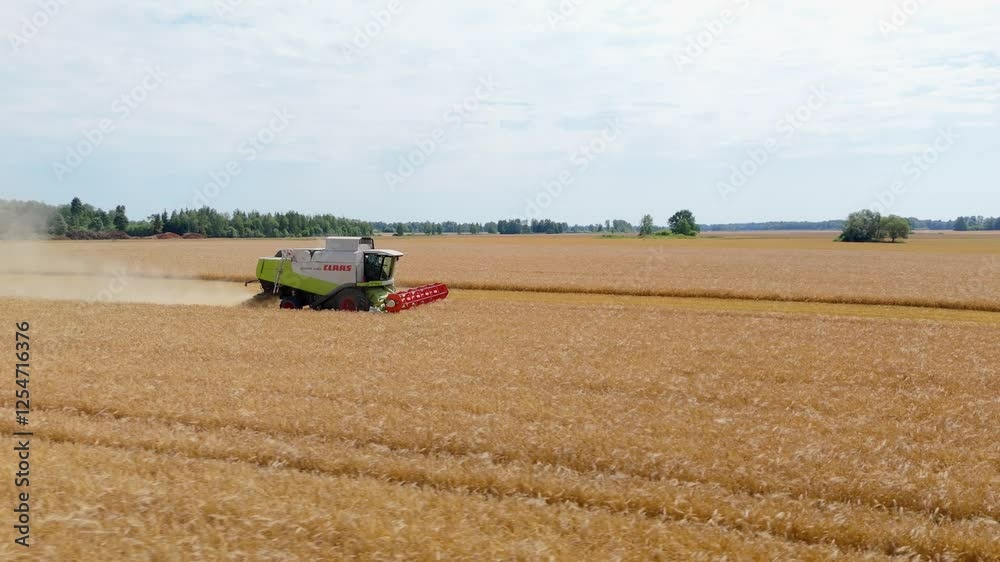 Drone shot of a combine harvester working in a crop field Drone shot of a combine harvester working in a crop field