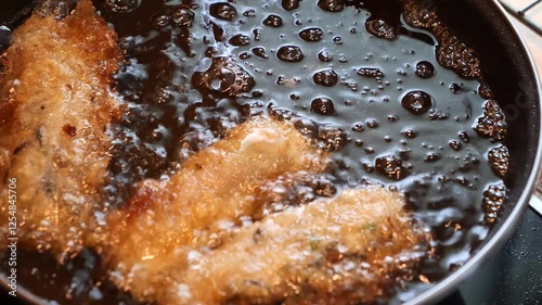 an homemade cooking spring rolls in a frying pan at home