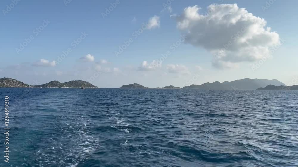 Panaromic view the waves behind motorboat sailing fast on a straight line, white foam blue waters created by the engine propeller clear skies, islands Panaromic view the waves behind motorboat sailing fast on a straight line, white foam blue waters created by the engine propeller clear skies, islands