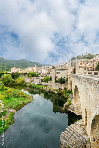 The medieval Pont Fortificat in Besalú, Spain, showcases stunning Romanesque architecture over the Fluvià River, offering a historic gateway to the charming Catalan village's rich heritage photo