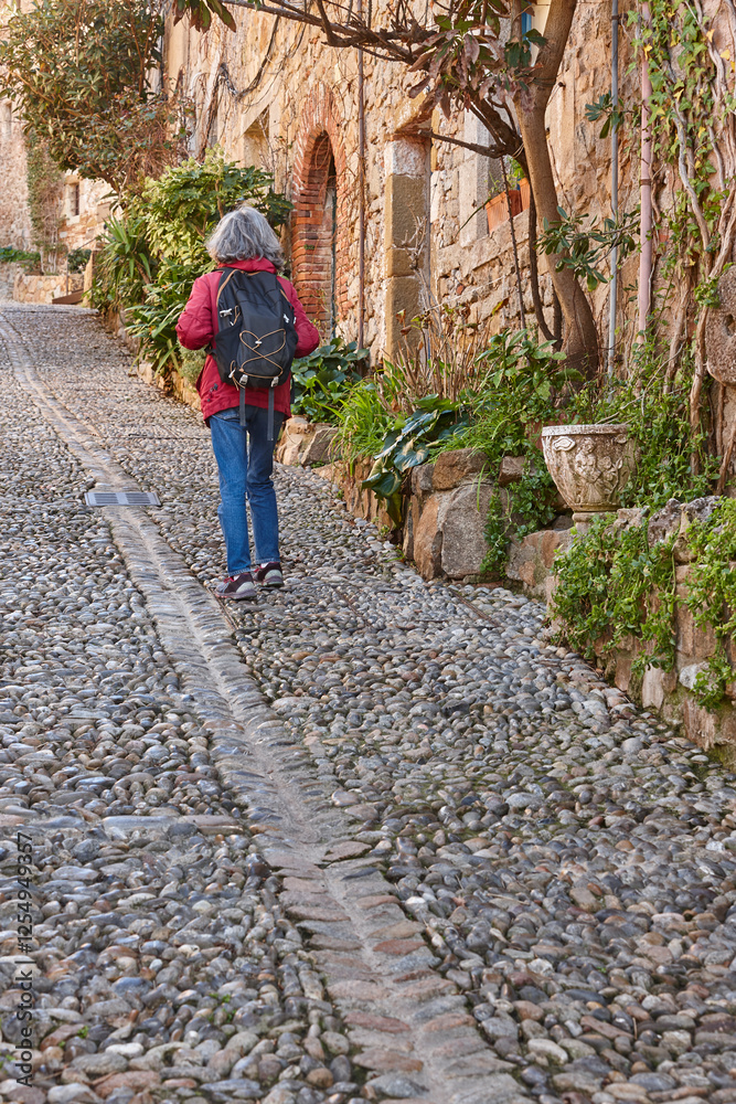 Woman walking. Cobblestone street. Tossa de Mar. Girona. Spain