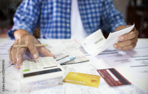 Asian man sitting at desk calculate receipt of expenses and all loan bills and try to find money to pay credit card debt, financial problem and inflation economy concept