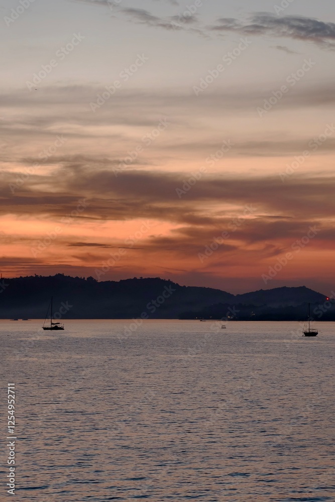 Serene Sunset Over Calm Sea with Sailboats and Silhouetted Hills
Serene Sunset Over Calm Sea with Sailboats and Silhouetted Hills