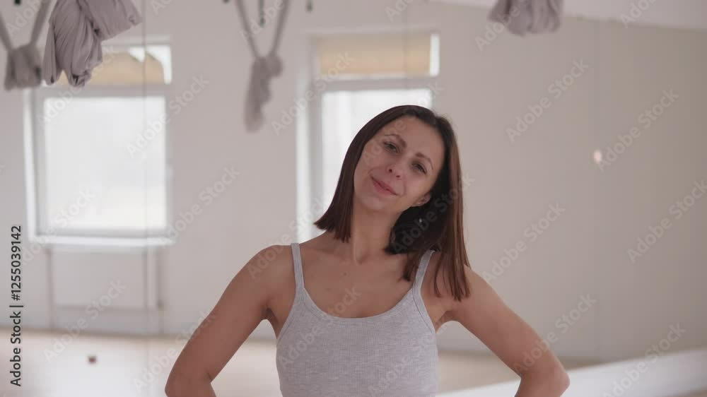 A woman stands confidently, striking a pose in a lively dance studio that radiates positivity and encouragement A woman stands confidently, striking a pose in a lively dance studio that radiates positivity and encouragement