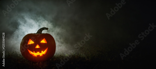 Ein gruseliger Halloween Kürbis im Nebel bei Nacht, Jack-O-Lantern, Copy Space photo