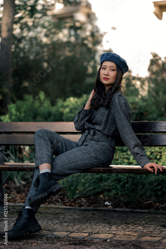 Asian woman sit on banch in park, girl in jumpsuit and blue beret, portrain of woman with long black hair, chinese woman photo, businesswoman in park photo