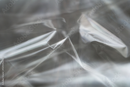 Crumpled clear plastic background, abstract glossy broken surface texture with creases