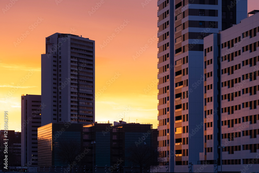 Modern city buildings reflecting the golden light of sunrise in Zaragoza, Spain, highlighting urban architecture and morning tranquility. Modern city buildings reflecting the golden light of sunrise in Zaragoza, Spain, highlighting urban architecture and morning tranquility.