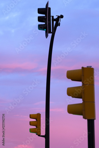 Traffic lights and signals under the purple and pink skies of sunrise in Zaragoza, Spain, capturing urban stillness and vibrant hues. photo