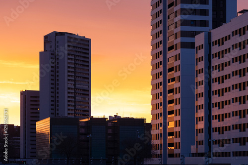 Modern city buildings reflecting the golden light of sunrise in Zaragoza, Spain, highlighting urban architecture and morning tranquility.