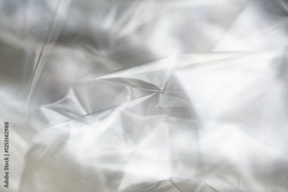 Obraz premium Crumpled clear plastic background, abstract glossy broken surface texture with creases