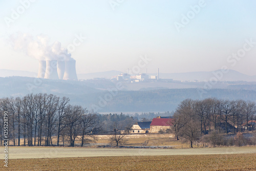 Obraz na płótnie A farmhouse in southern Czechia and the Temelin Nuclear Power Plant on the horizon. Cold winter morning. w salonie