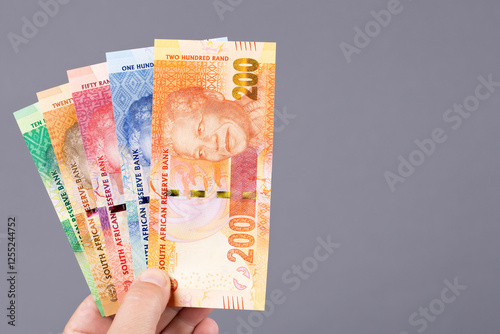 South African money in the hand on a gray background