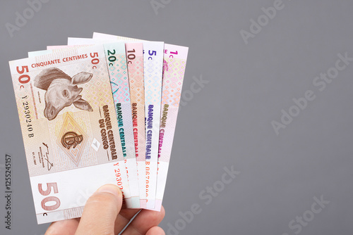 Old Congolese money in the hand on a gray background