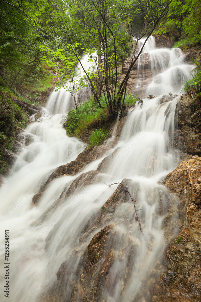 Fototapeta premium Wasserfall nach einem Starkregen am Walchensee bei Urfeld in den deutschen Alpen. 