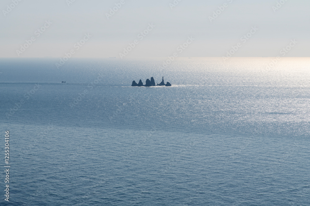 High-angle view of the rocks on the sunlight-reflected sea High-angle view of the rocks on the sunlight-reflected sea