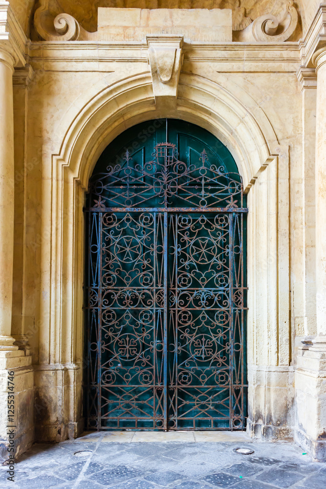 Fototapeta premium Ornate Iron Gate of a Historic Arched Entrance on Stone Structure