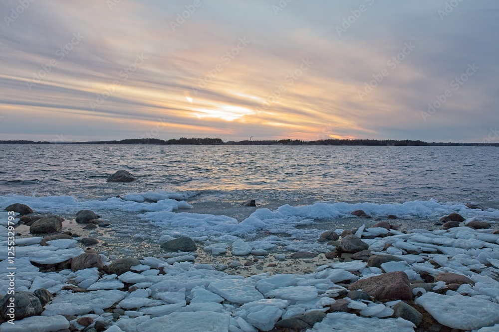 View of sunset from snow and ice covered rocky seashore on a cold winter day, Lauttasaari, Helsinki, Finland. View of sunset from snow and ice covered rocky seashore on a cold winter day, Lauttasaari, Helsinki, Finland.