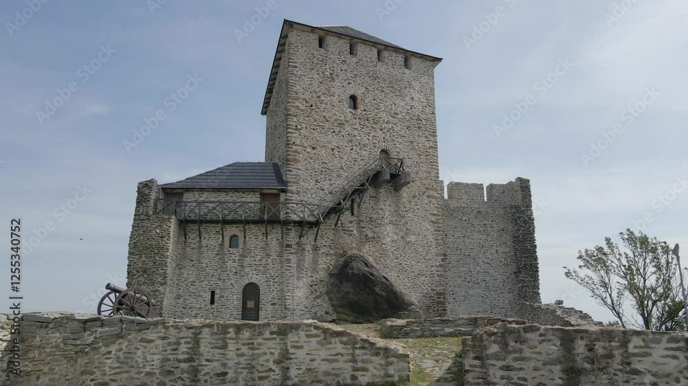 Exploring a historic castle with a stone tower and cannon on a sunny day in the countryside Exploring a historic castle with a stone tower and cannon on a sunny day in the countryside