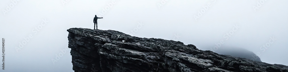 Obraz premium Person on Rocky Outcrop in Fog