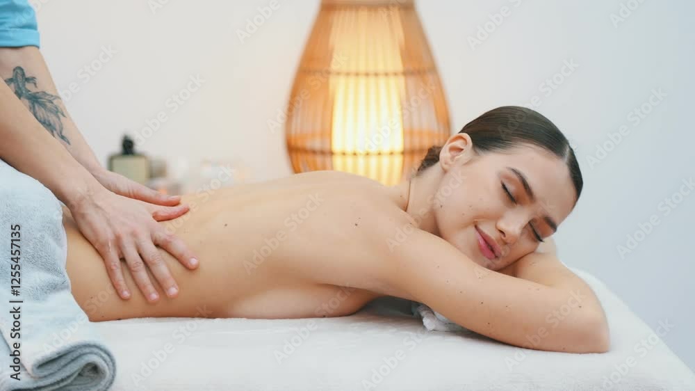 Lying down. Relaxed young woman getting massage by therapist in spa salon. Lying down. Relaxed young woman getting massage by therapist in spa salon.