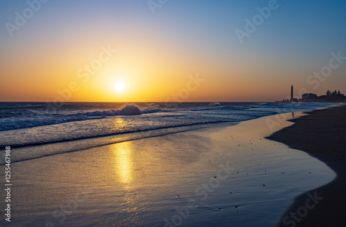 Sunset at Maspalomas Beach with Faro de Maspalomas lighthouse in Gran Canaria, Spain